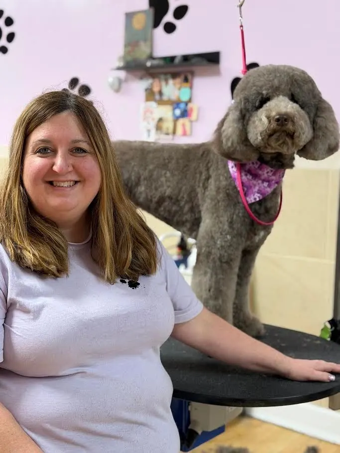 Shelly with a freshly trimmed grey poodle and a pink bandana