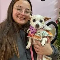 Shilo holding a small Chihuahua in a floral sweater